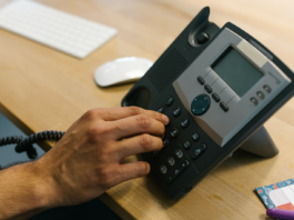 Business Telephone - Person Dialing the Telephone